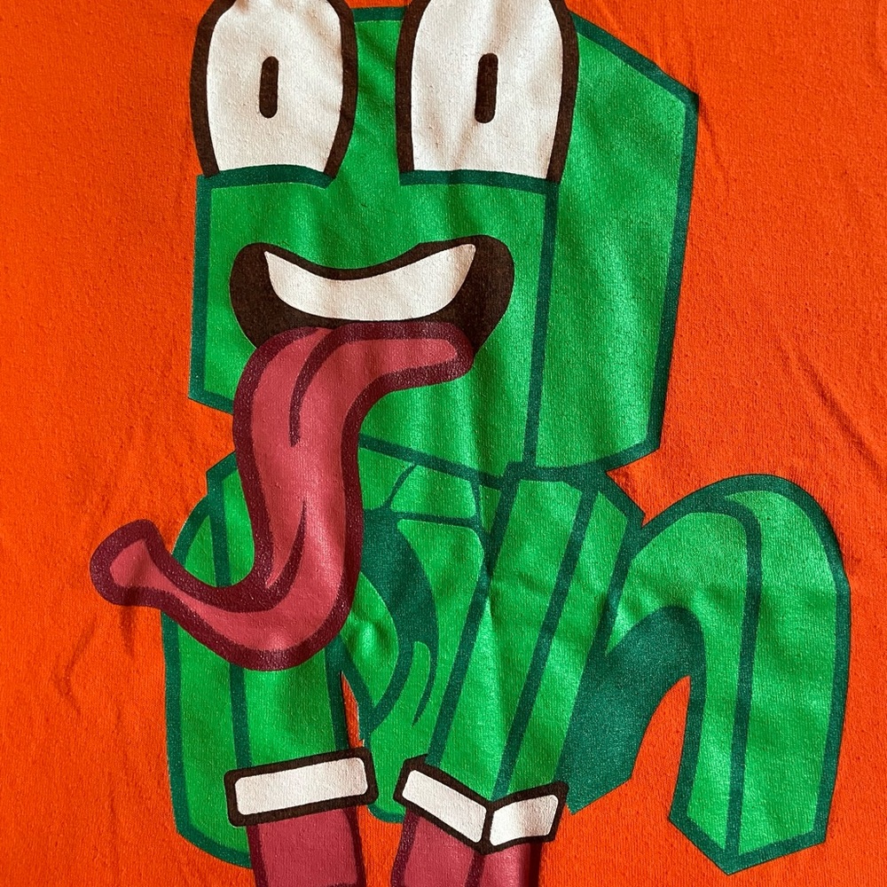 Orange T-Shirt with Green Cartoon Character UNSPEAKABLE